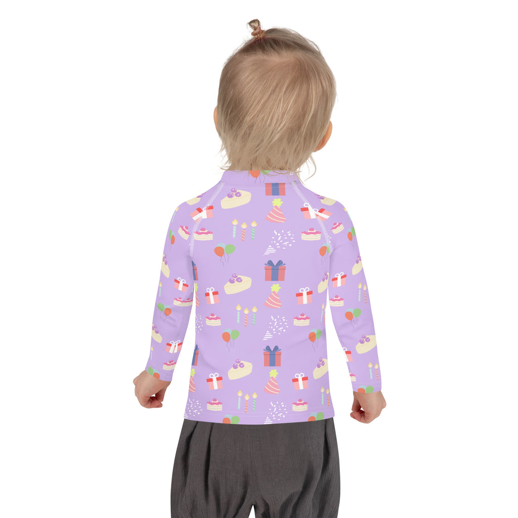 A child wearing a lavender girls birthday party sleeve rash guard swim shirt with UPF 50 plus featuring cakes gifts and candles