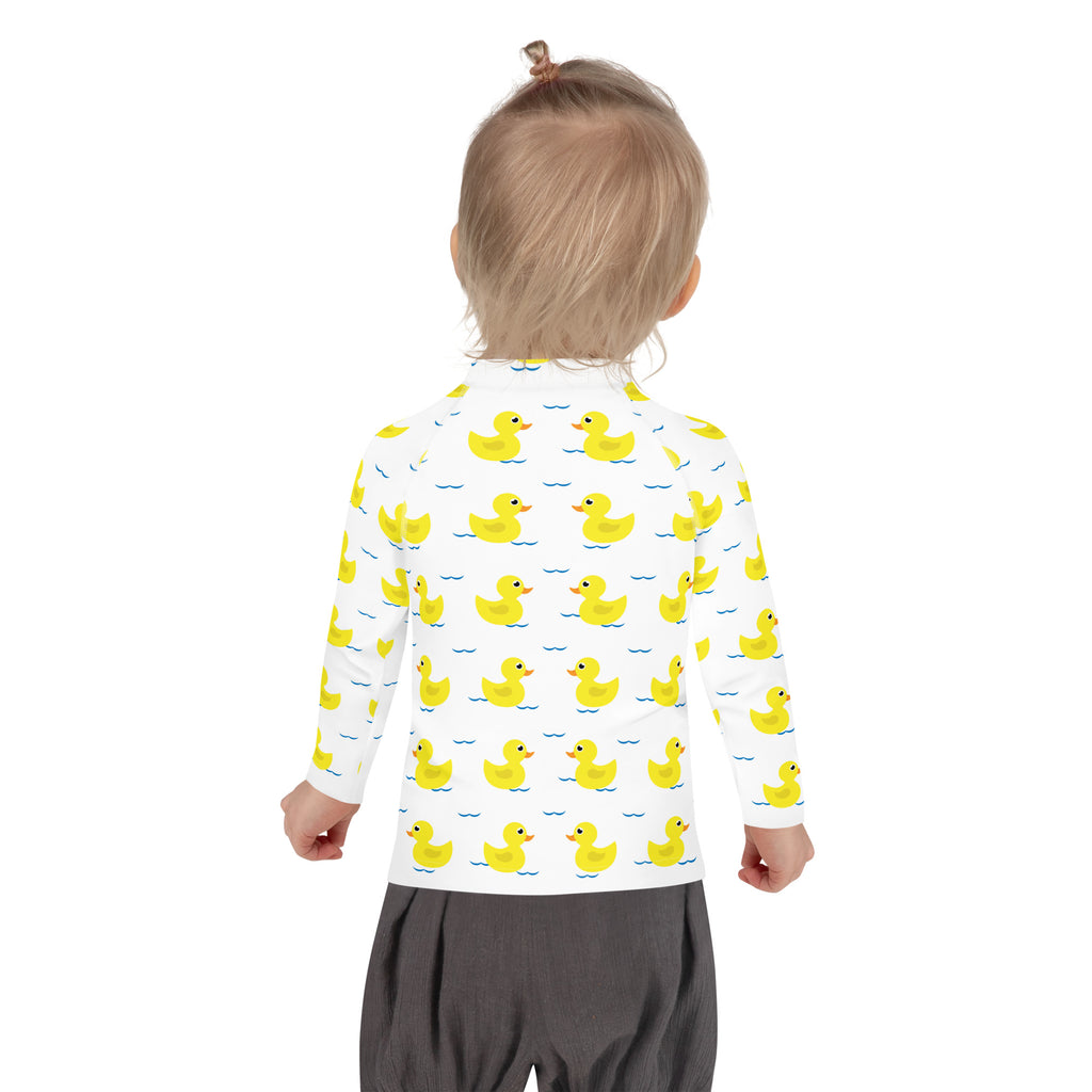 White long-sleeved kids rash guard swim shirt with yellow ducks on blue waves and upf 50 plus protection