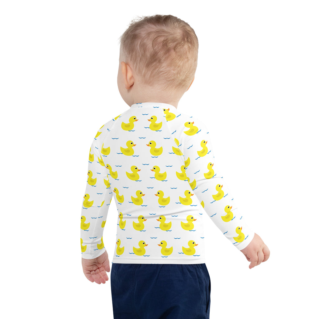 White long sleeve kids rash guard swim shirt with yellow duck pattern on blue waves and UPF 50 plus protection