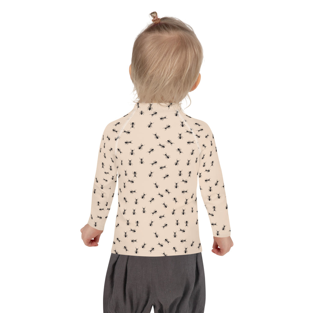 Beige long-sleeved toddler rash guard swim shirt with black ant print and upf 50 plus sun protection