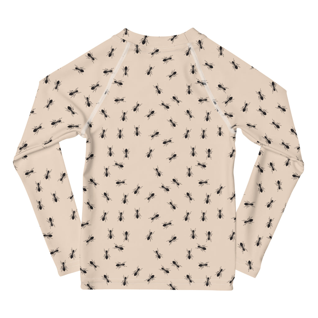 Beige long sleeve kids rash guard swim shirt with black ant pattern and UPF 50 plus sun protection