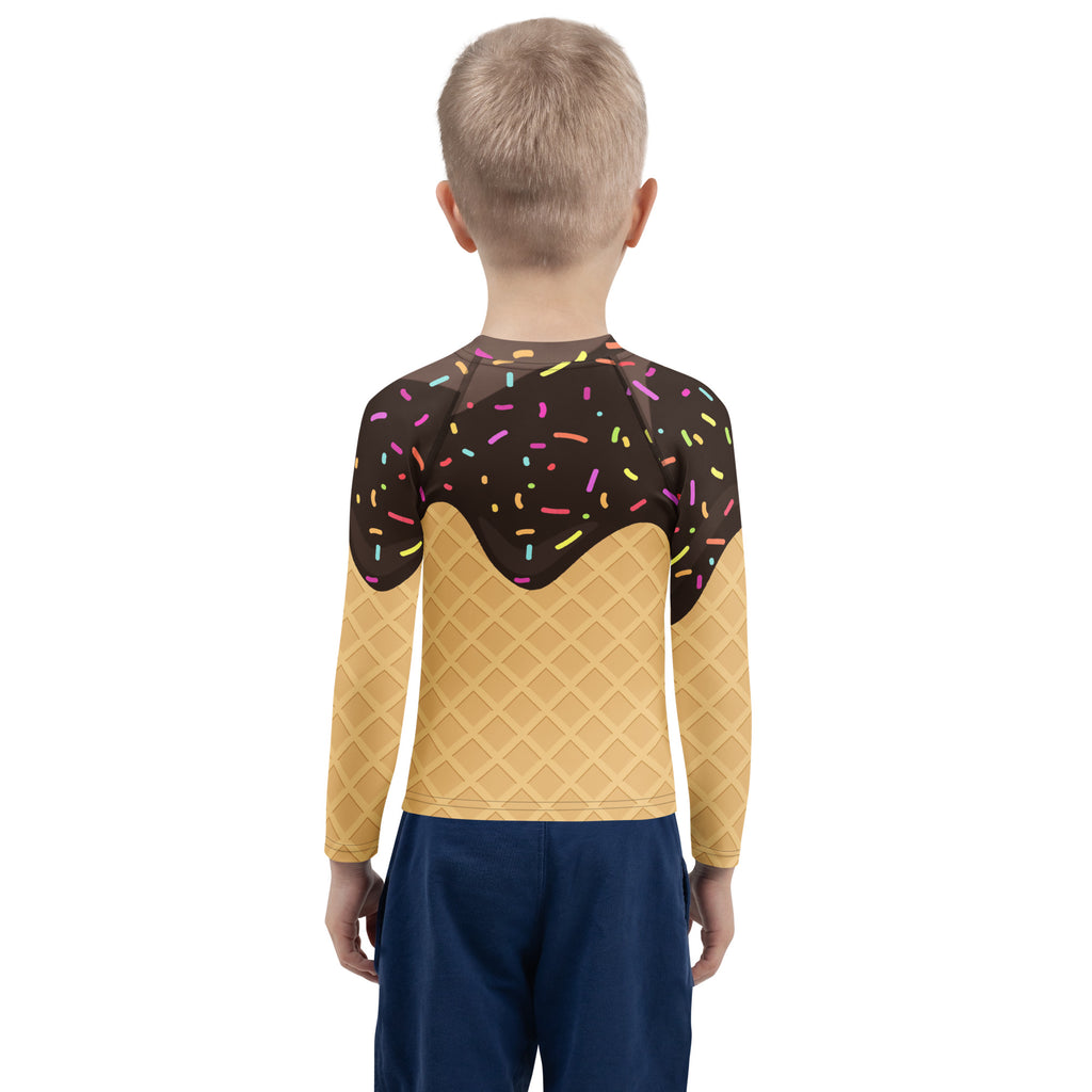 A child wears a birthday boy chocolate ice cream cone long sleeve rash guard with upf 50 plus featuring waffle and sprinkles design