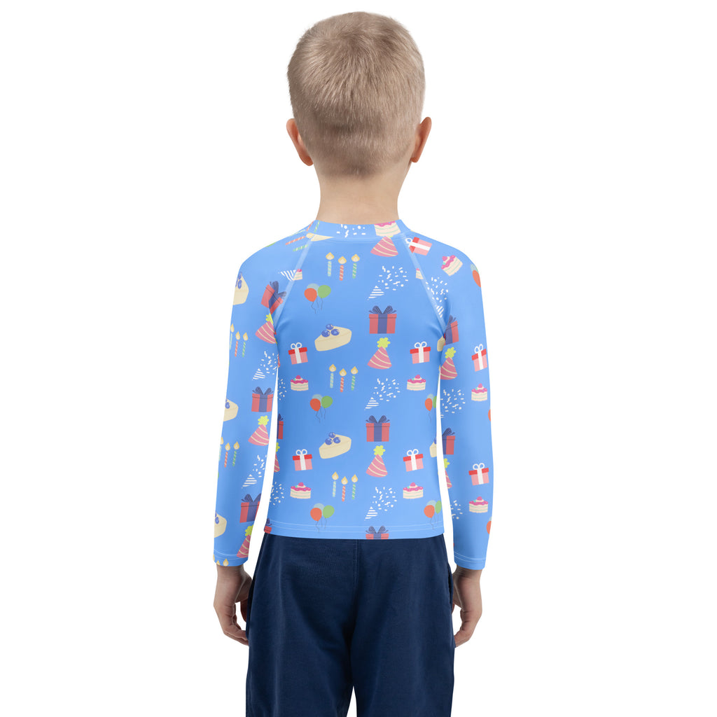 A child wearing a kids blue birthday party long sleeve rash guard swim shirt with colorful birthday graphics and upf 50+ protection