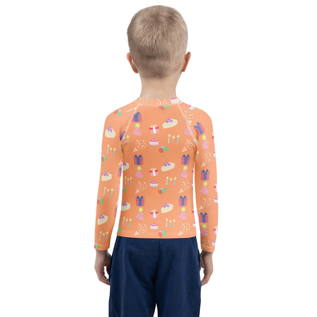 Orange long sleeve rash guard swim shirt with upf 50 plus featuring playful birthday cakes gifts and candles pattern