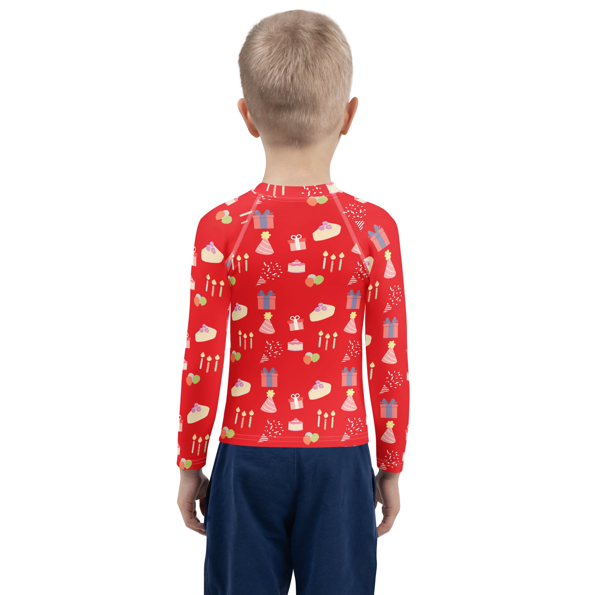 Child wearing a red long-sleeve shirt with birthday pattern on a white background
