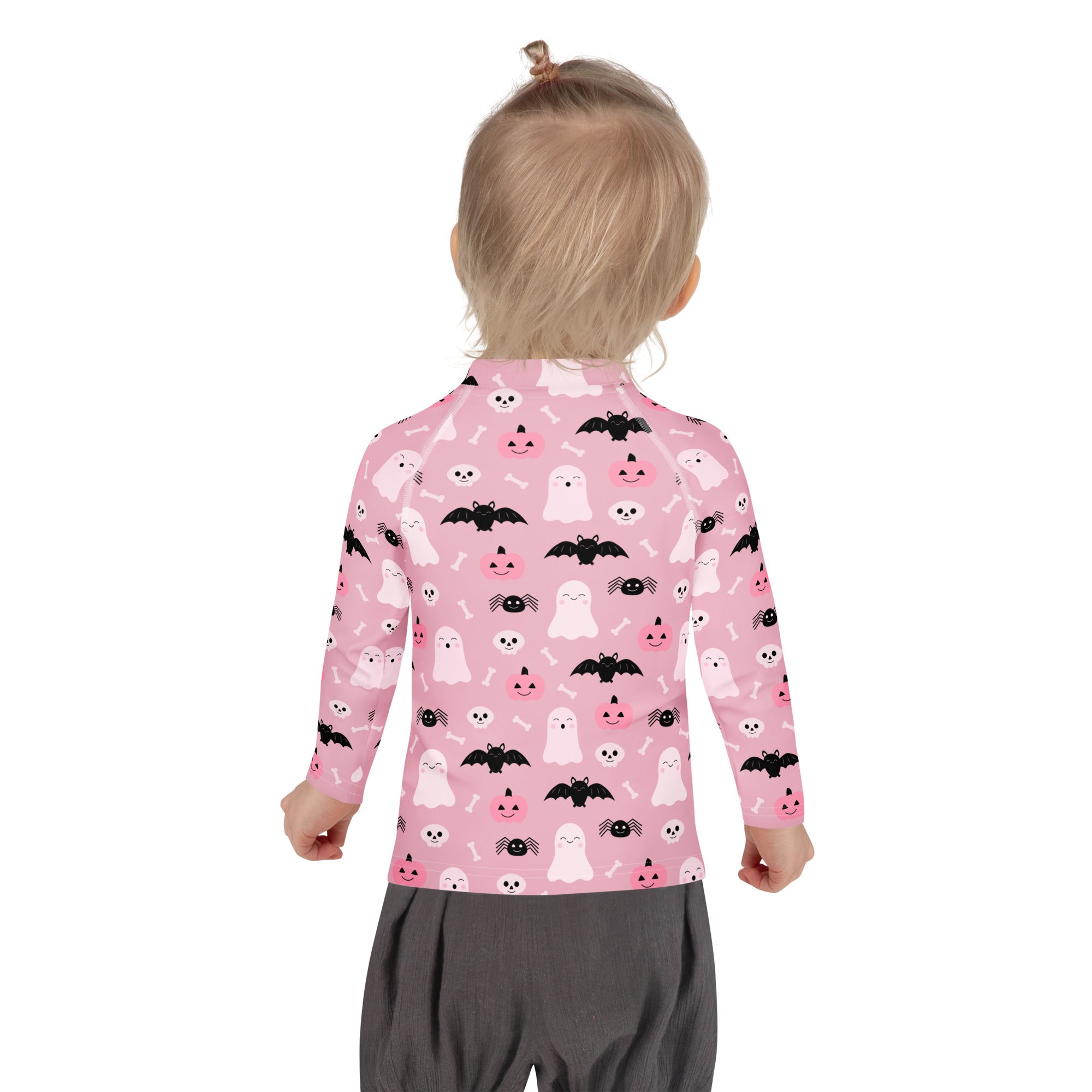 Girls pink long sleeve rash guard swim shirt with playful white ghosts black bats and smiling jack o lanterns pattern