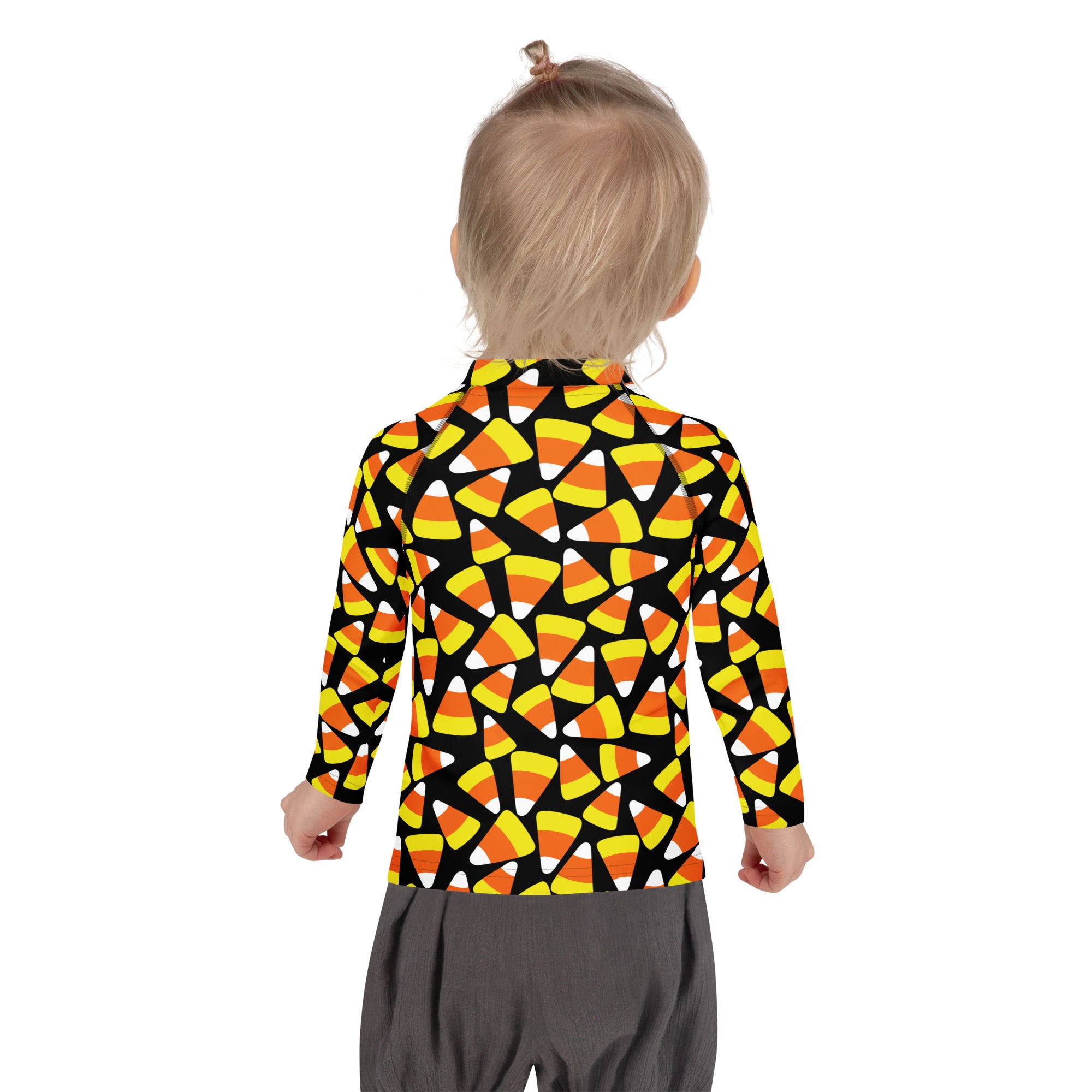 A child wearing a kids candy corn halloween long sleeve rash guard swim shirt with upf 50 plus in black