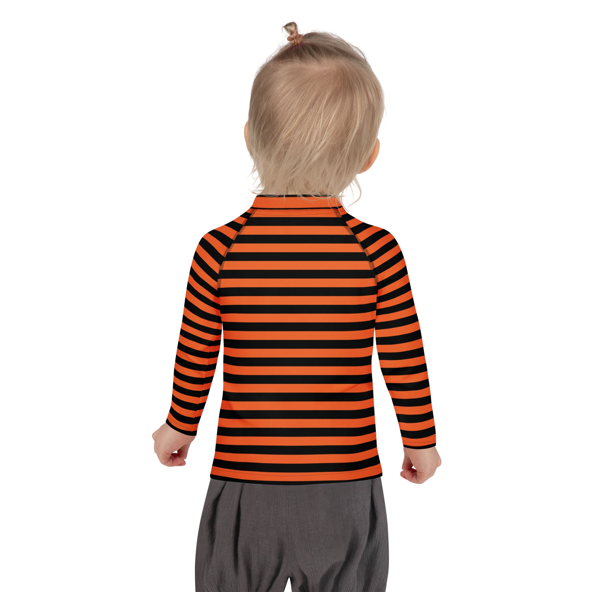 A child wearing a kids orange and black halloween long sleeve rash guard swim shirt with upf 50 and stripes