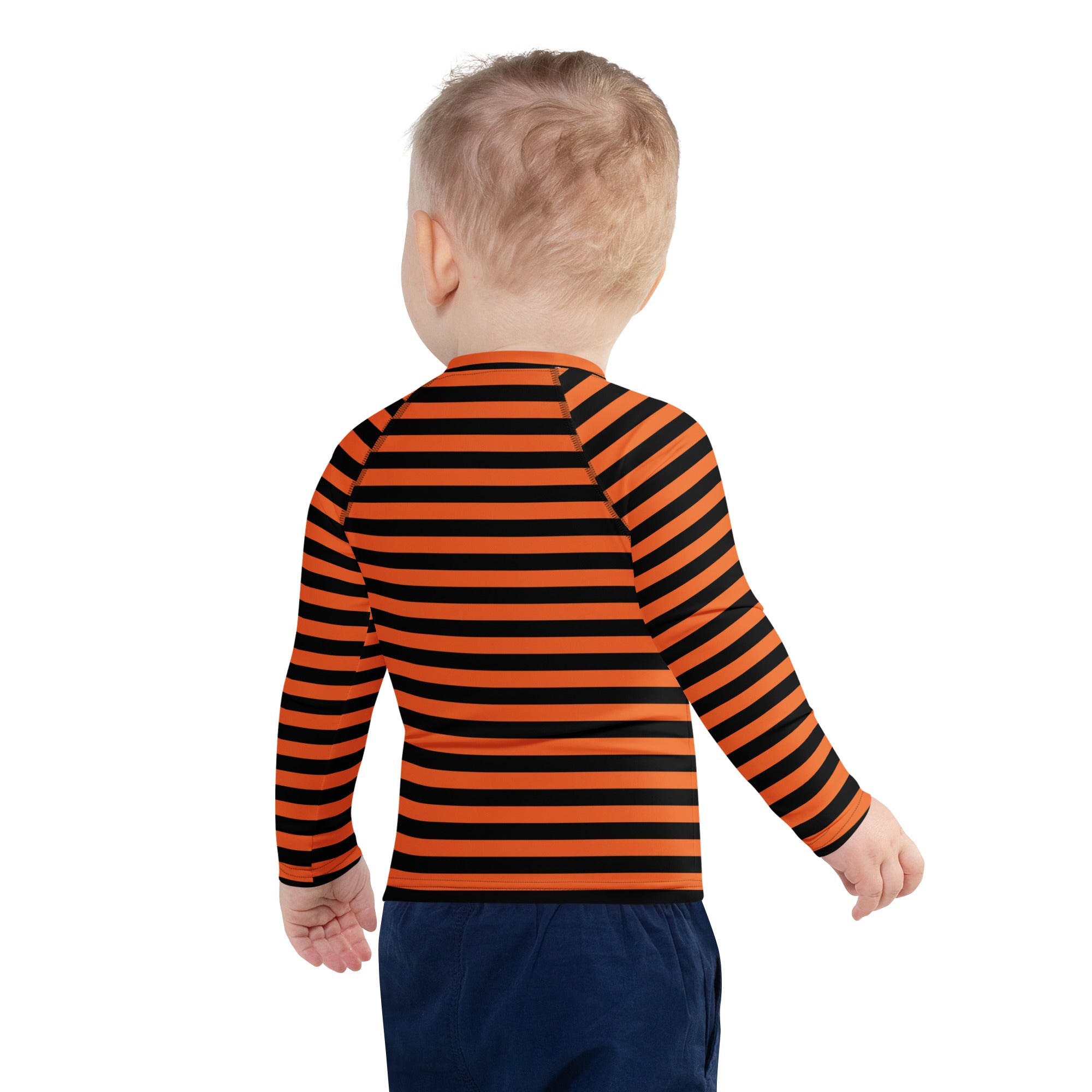 A child wearing a kids orange and black halloween long sleeve rash guard swim shirt with UPF 50 plus protection