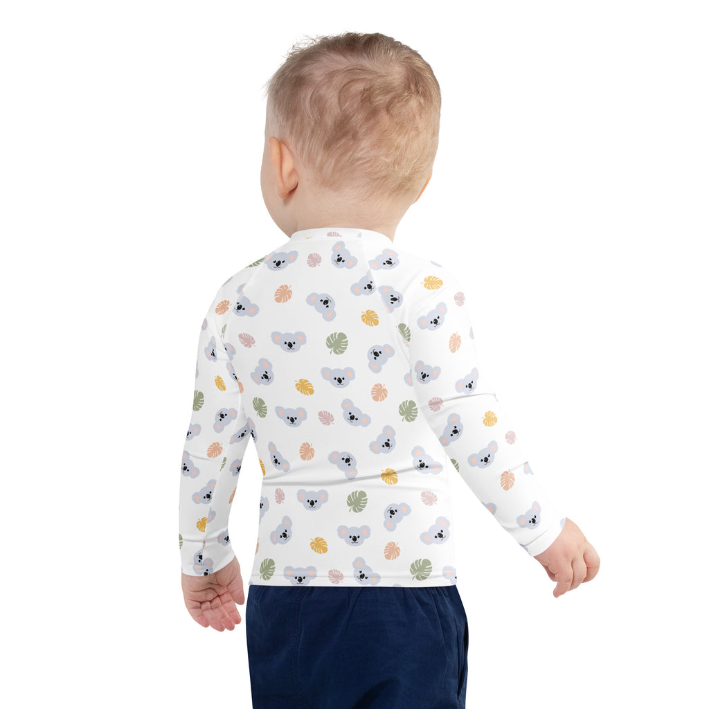 White long-sleeved baby shirt with gray koalas and colorful tropical leaves designed as a kids koala bear rash guard with upf 50+