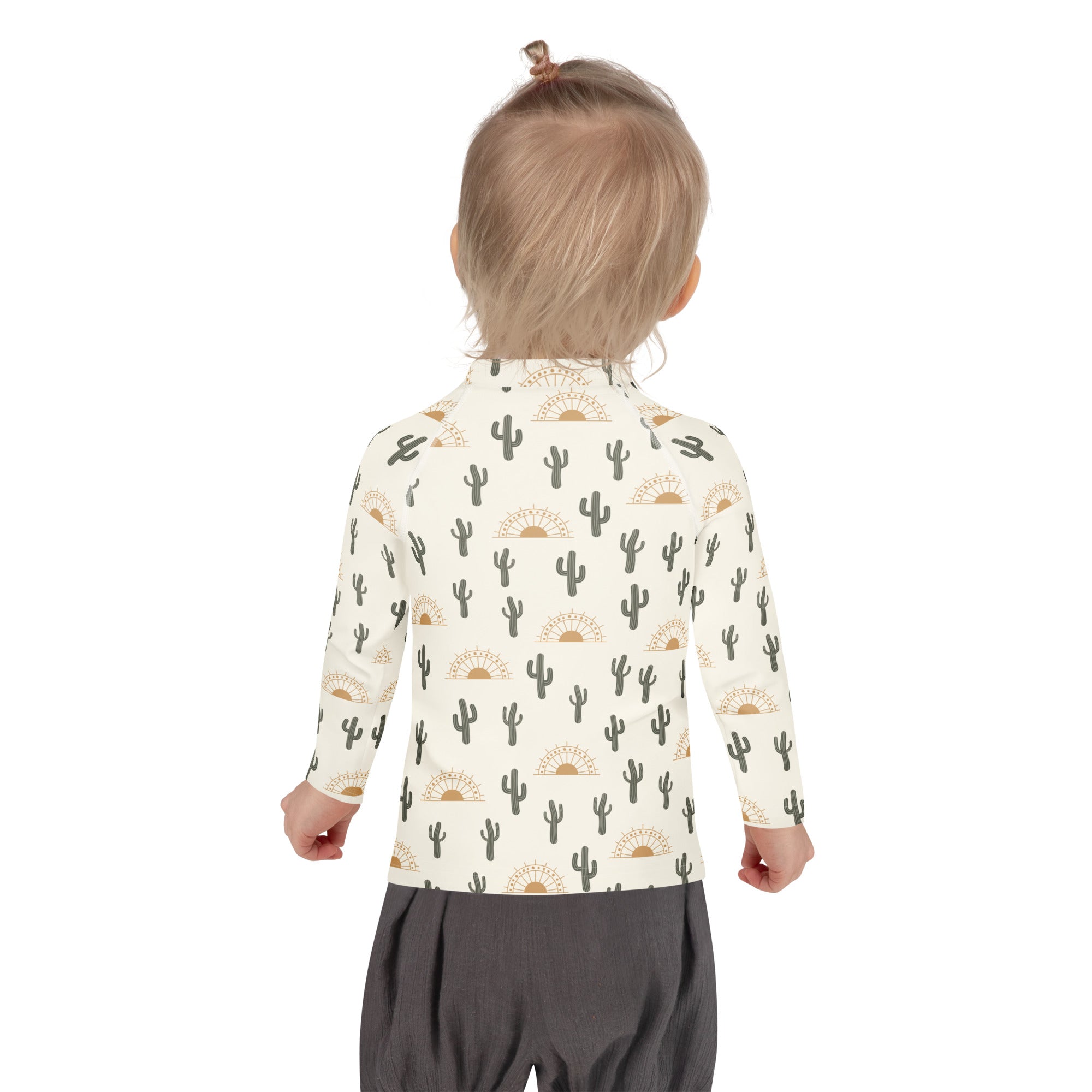 A child wearing a cream-colored kids cactus desert sunrise long sleeve rash guard swim shirt with UPF 50+ protection