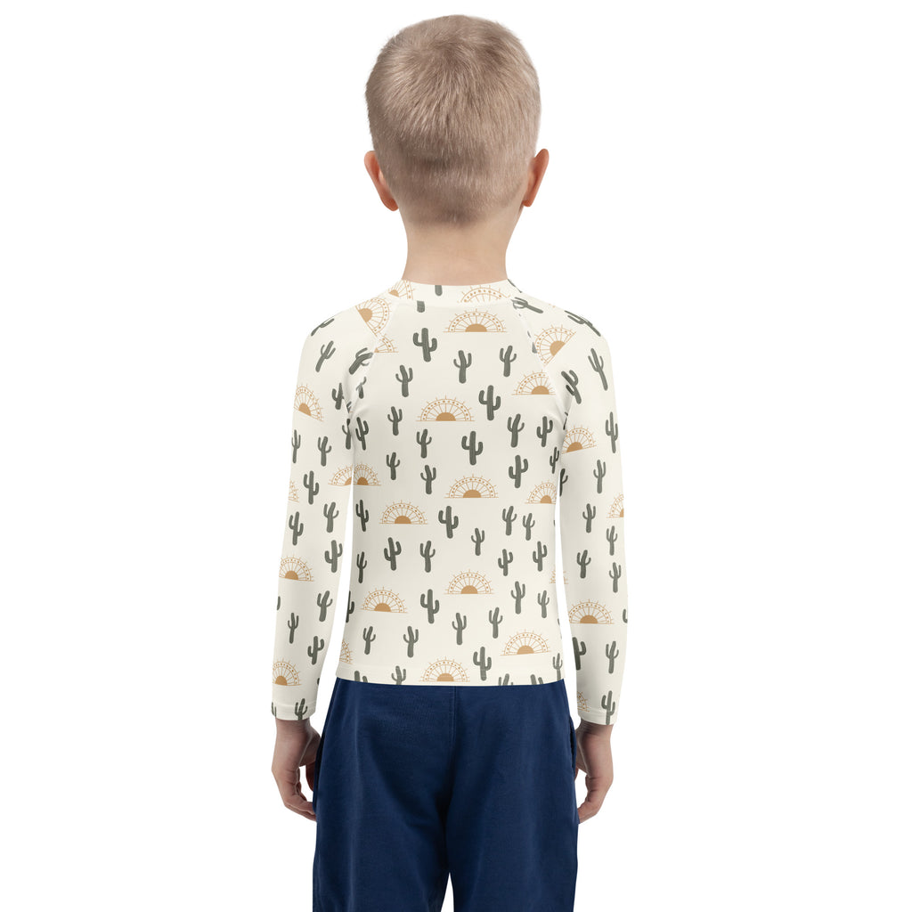 Kids cream-colored long sleeve rash guard swim shirt with black cacti gold suns pattern upf 50+ for sun protection
