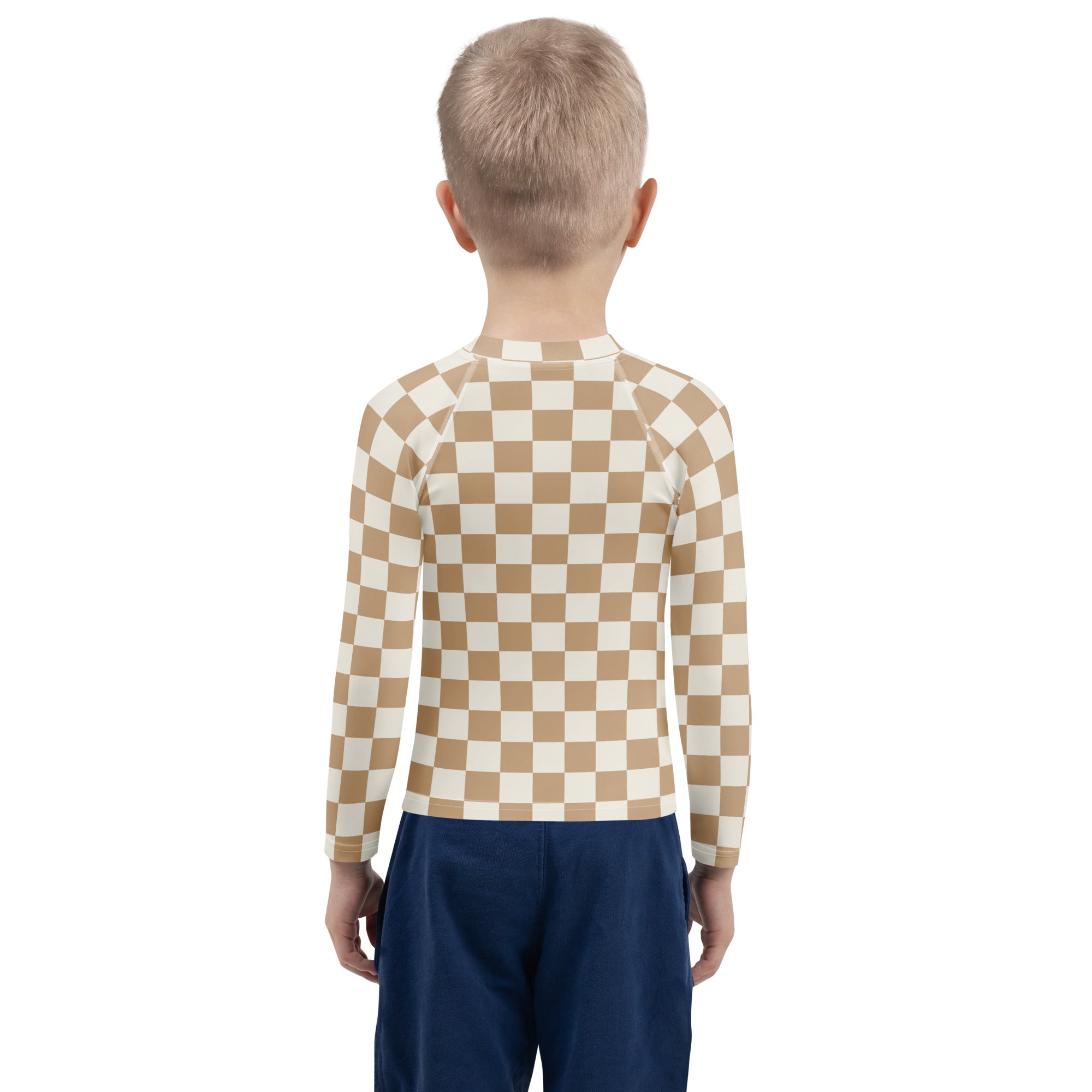 A child wearing a beige and cream checkered kids sand checkerboard long sleeve rash guard with UPF 50 plus