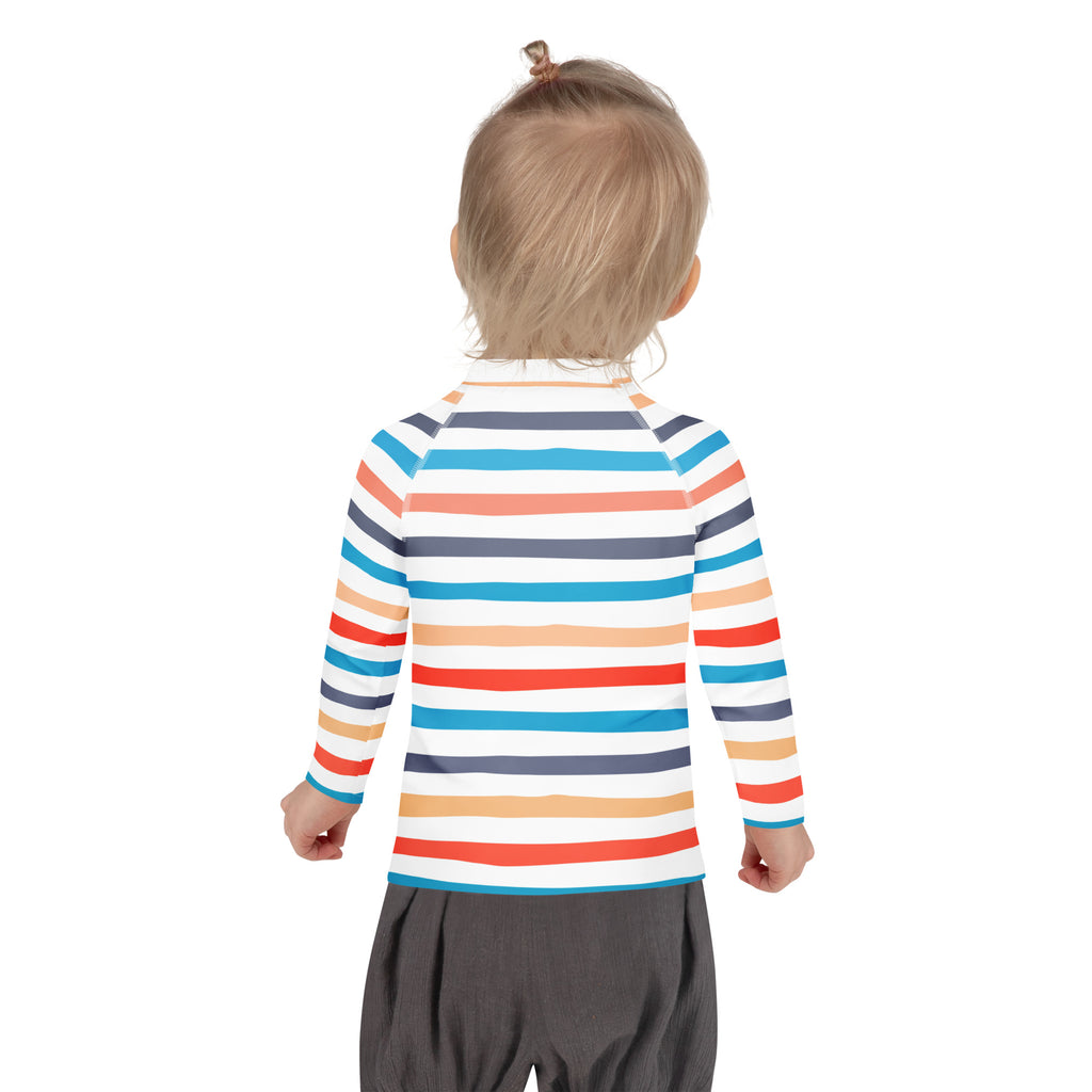 A child wearing a kids coastal stripes long sleeve rash guard swim shirt with UPF 50 plus in white blue orange and gray stripes