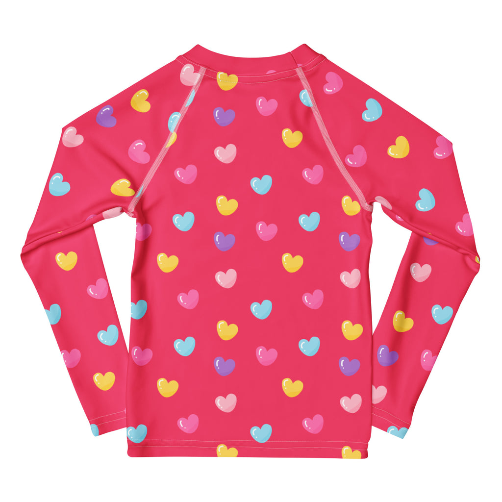A vibrant pink long sleeve rash guard with colorful hearts pattern and upf 50 plus for girls swimwear