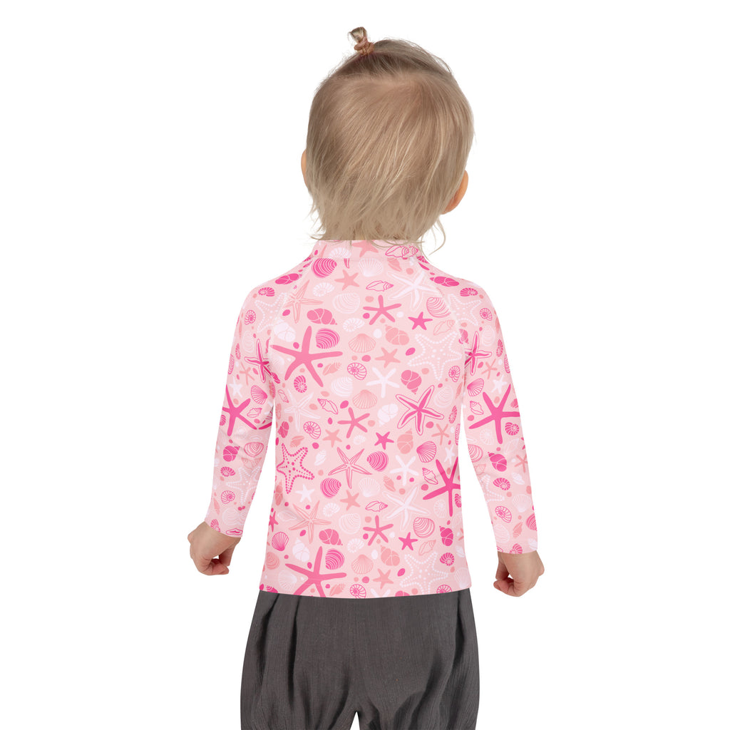 Girls pink long sleeve rash guard swim shirt with upf 50 and playful sea-themed starfish and seashell pattern