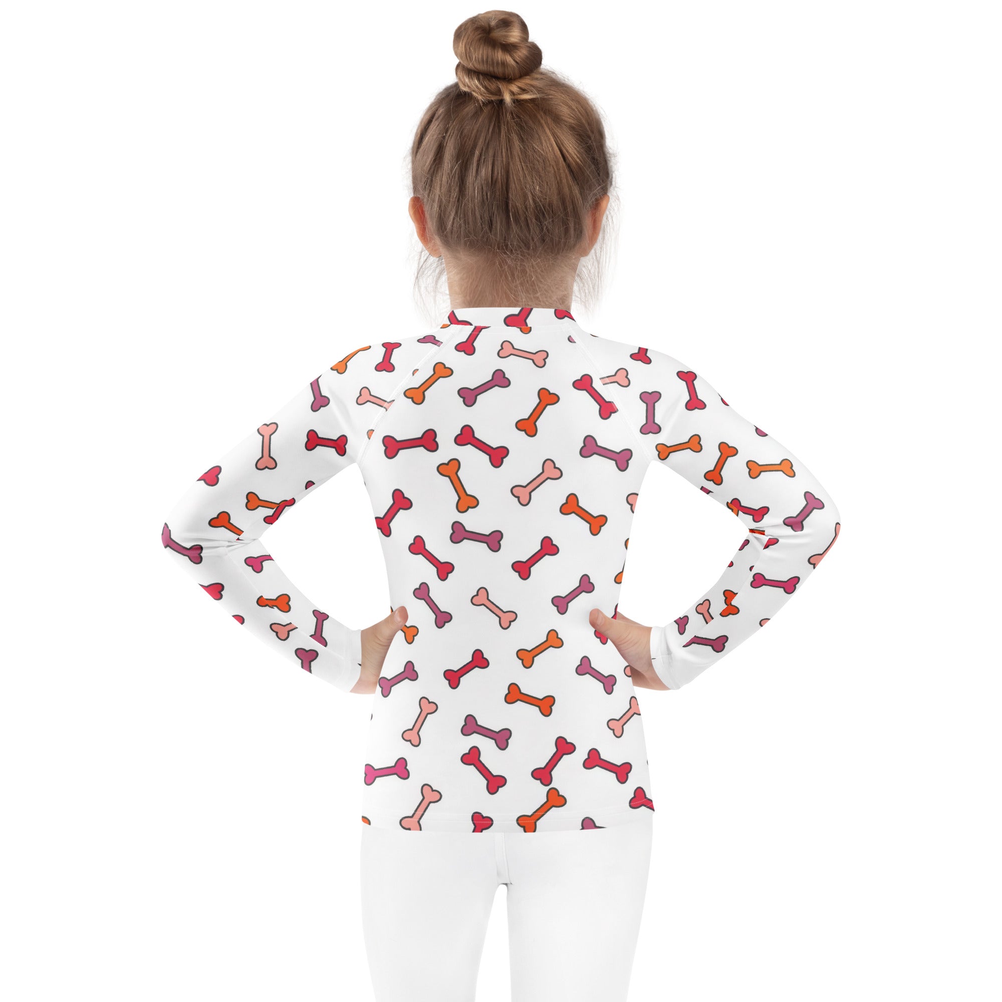 White kids long sleeve rash guard swim shirt with playful pink orange and red bone pattern and upf 50+ protection