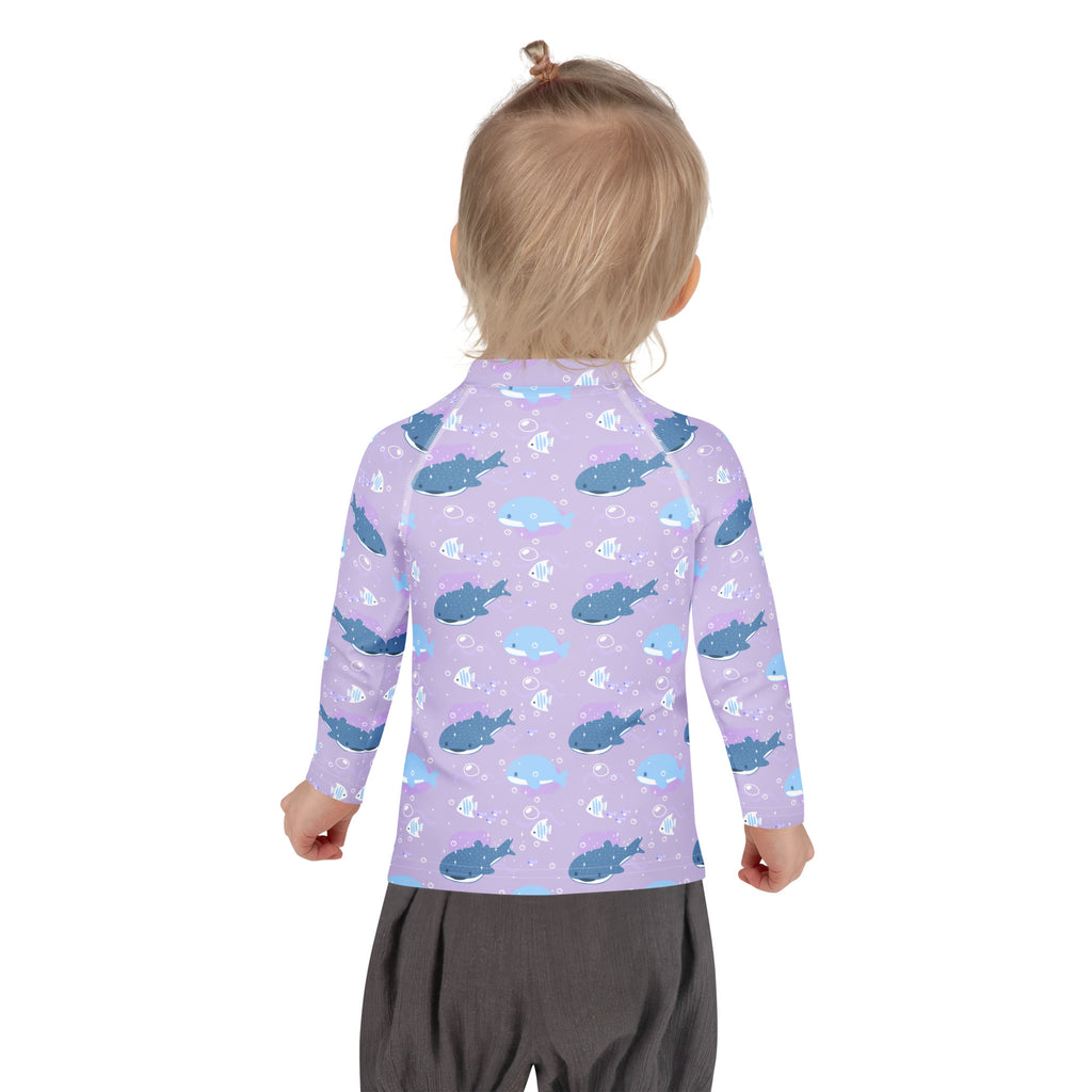 Girls purple long sleeve rash guard with playful blue shark pattern and UPF 50+ sun protection for swim use