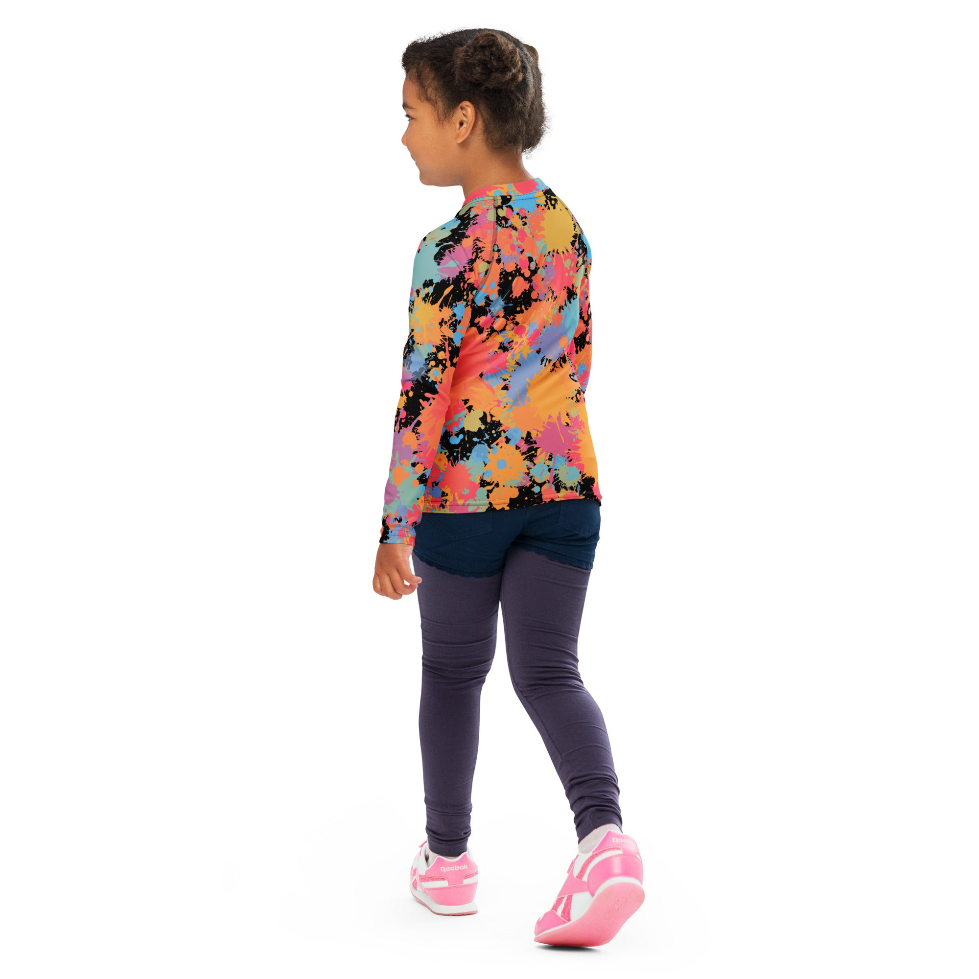 A child wearing a kids paint splatter long sleeve rash guard swim shirt in vibrant multicolored tie-dye with upf 50+