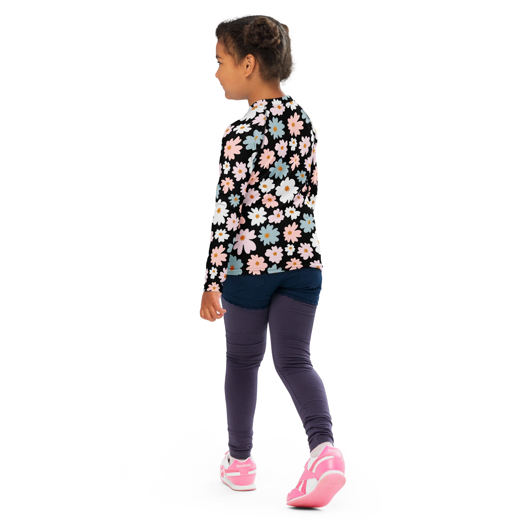 A child wearing a black girls flower scale long sleeve rash guard swim shirt with colorful daisies and upf 50+ protection
