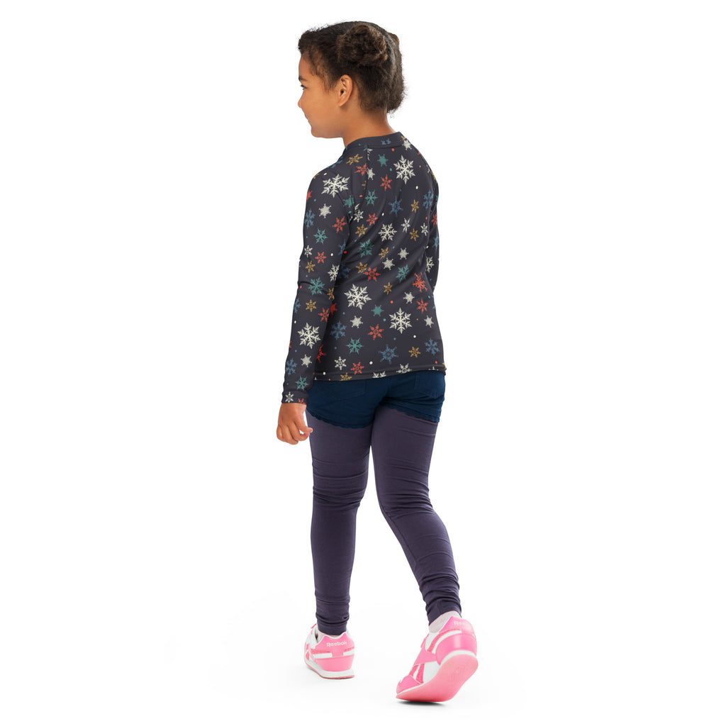 A child wearing a dark gray kids colorful snowflakes long sleeve rash guard swim shirt with upf 50 plus and navy leggings