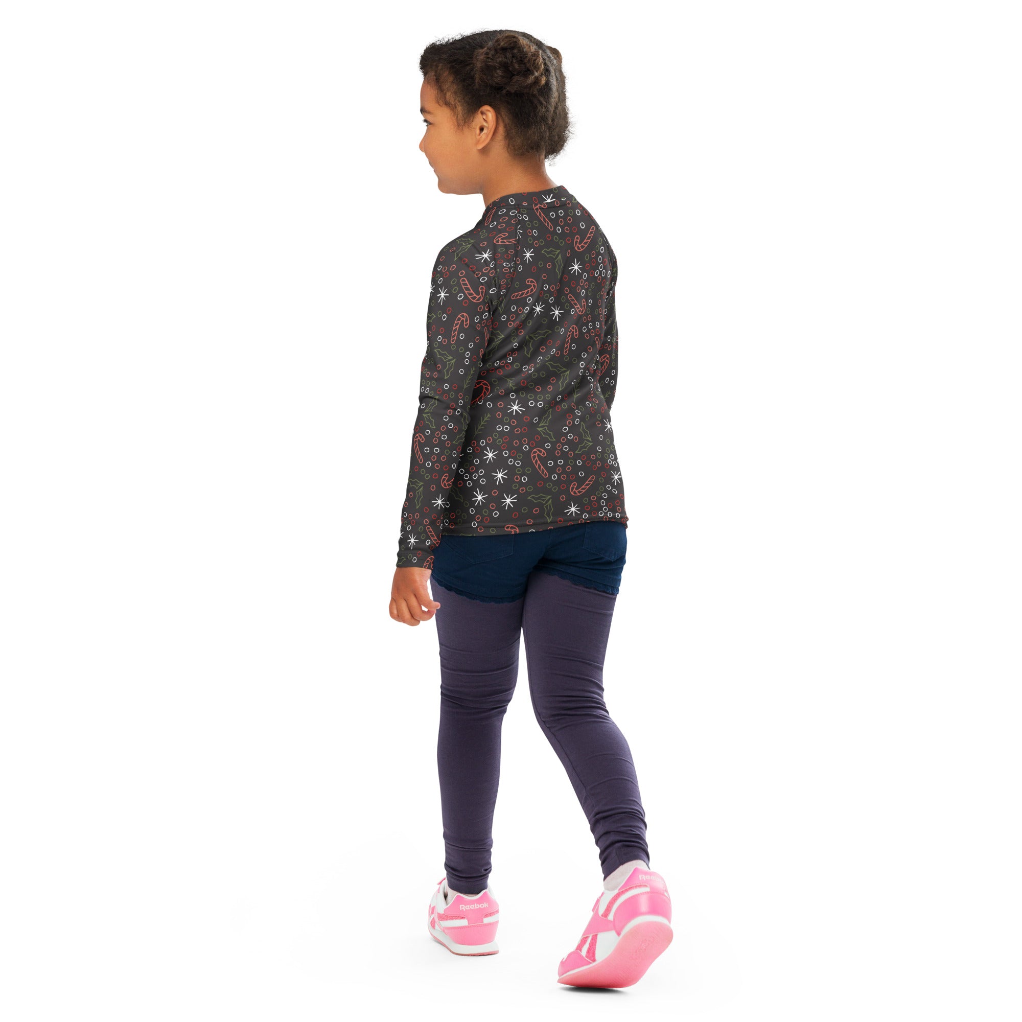 A child wearing a kids candy cane and holly christmas long sleeve rash guard swim shirt with upf 50+ in dark gray