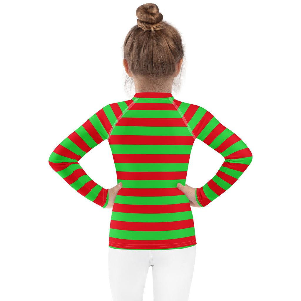 A child wearing a kids red and green striped Christmas long sleeve rash guard swim shirt with UPF 50+ protection