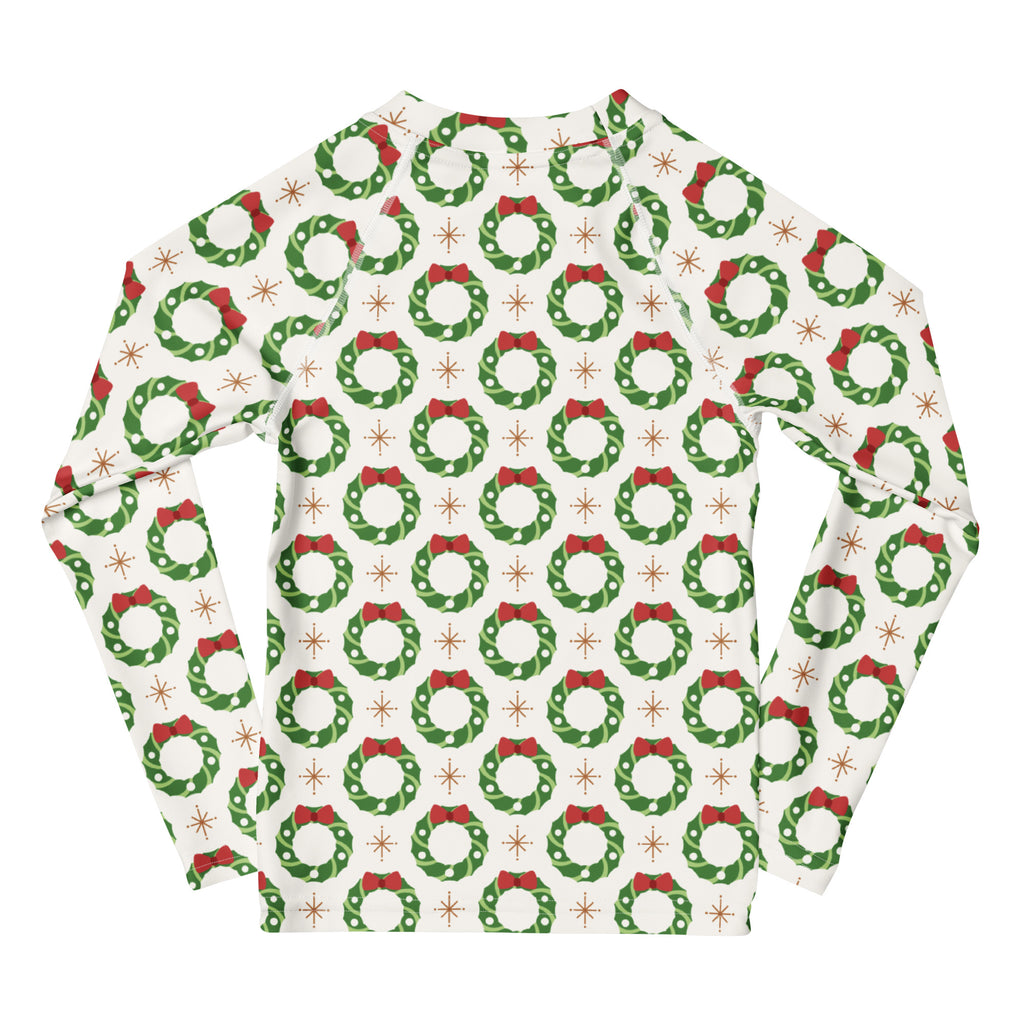 Kids Christmas wreath long sleeve rash guard swim shirt with UPF 50 plus featuring green wreaths red bows on off-white background