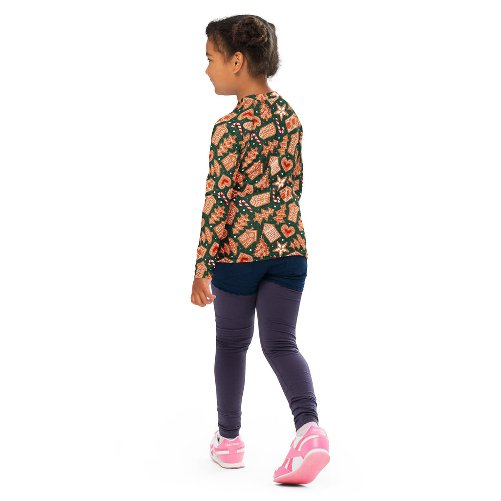 A child wearing a kids green gingerbread Christmas long sleeve rash guard swim shirt with UPF 50 and navy leggings