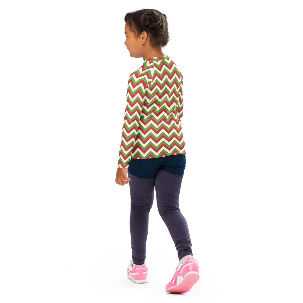 A child wearing a kids red and green chevron Christmas long sleeve rash guard swim shirt with UPF 50+ protection