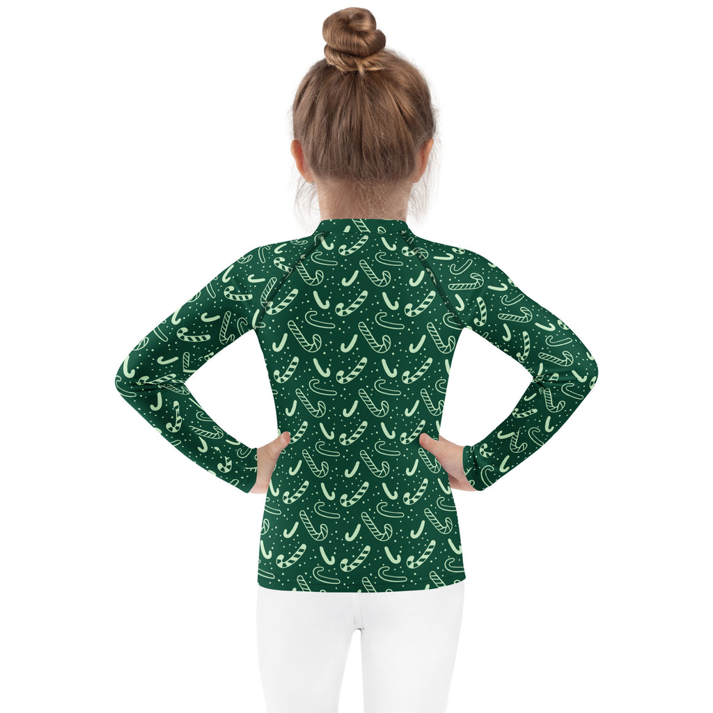 Kids green candy cane christmas long sleeve rash guard swim shirt with upf 50 plus featuring playful white candy cane pattern