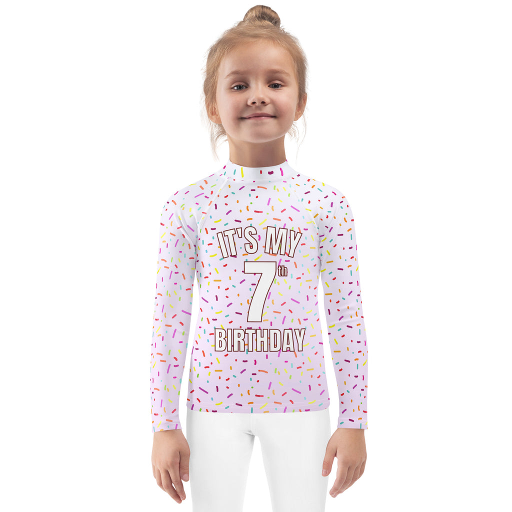 White long-sleeved girls rash guard swim shirt with colorful sprinkles and my 7th birthday text with upf 50+