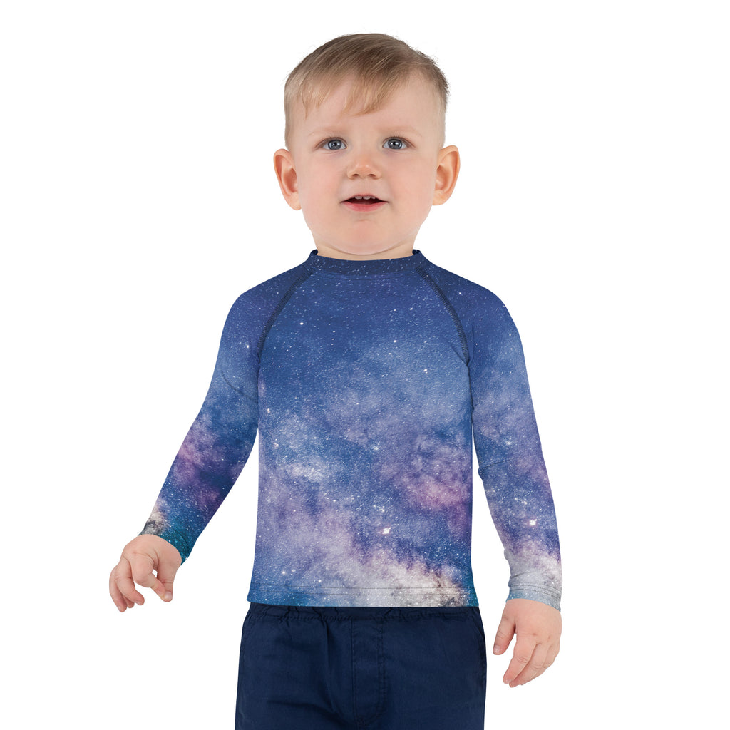 A child wearing a girls realistic galaxy long sleeve rash guard swim shirt with upf 50 plus sun protection in blue and purple