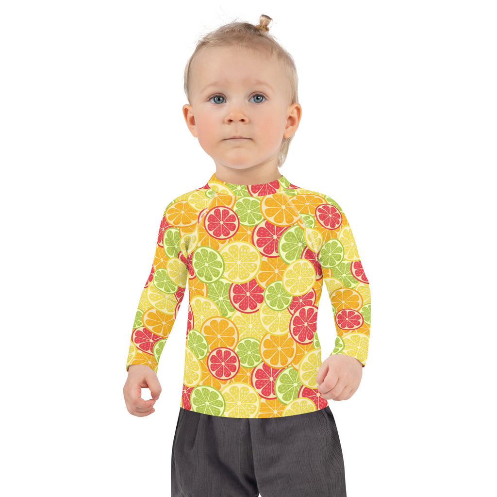 A vibrant kids citrus fruit long sleeve rash guard swim shirt with upf 50 plus featuring bright sliced fruit pattern