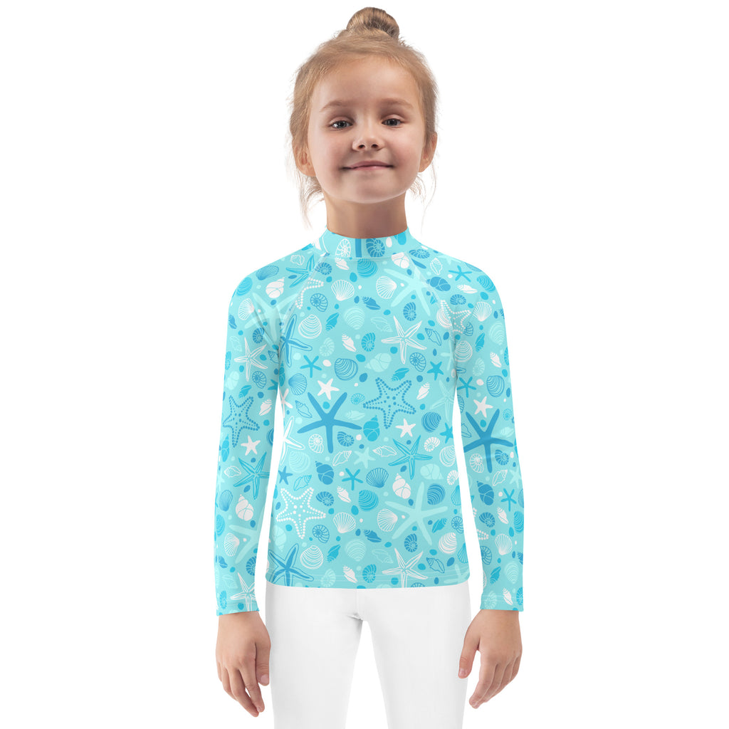 A light blue kids long sleeve rash guard swim shirt with starfish and seashell pattern and UPF 50+ protection