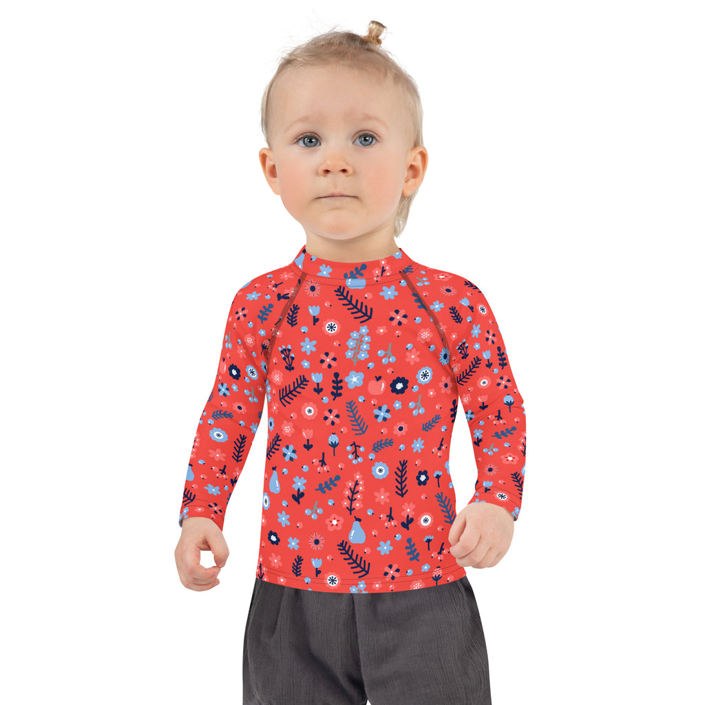 Girls red long sleeve rash guard swim shirt with playful blue and dark green floral pattern and upf 50 plus protection