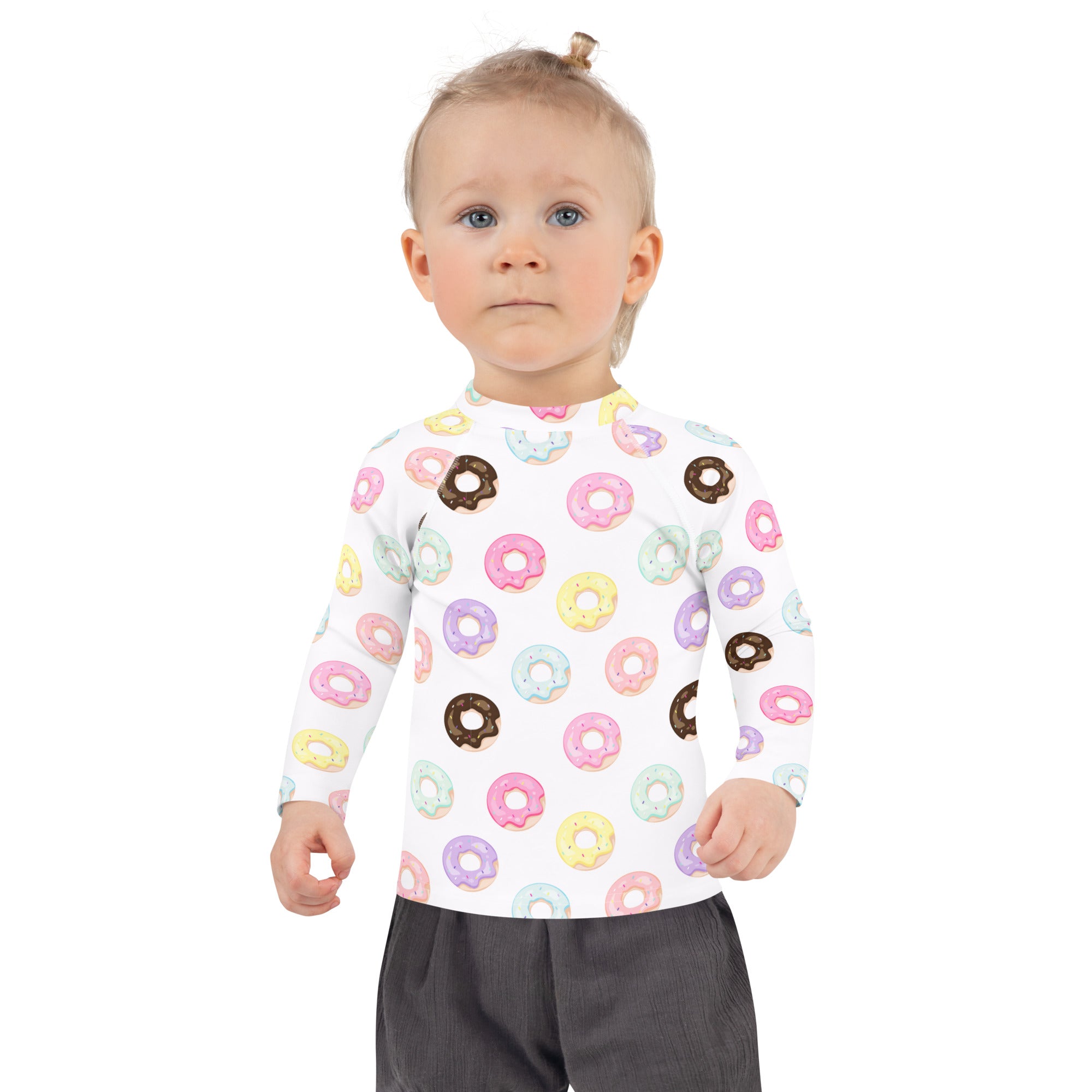 A child wearing a white kids colorful donuts long sleeve rash guard swim shirt with upf 50 and pastel donut prints