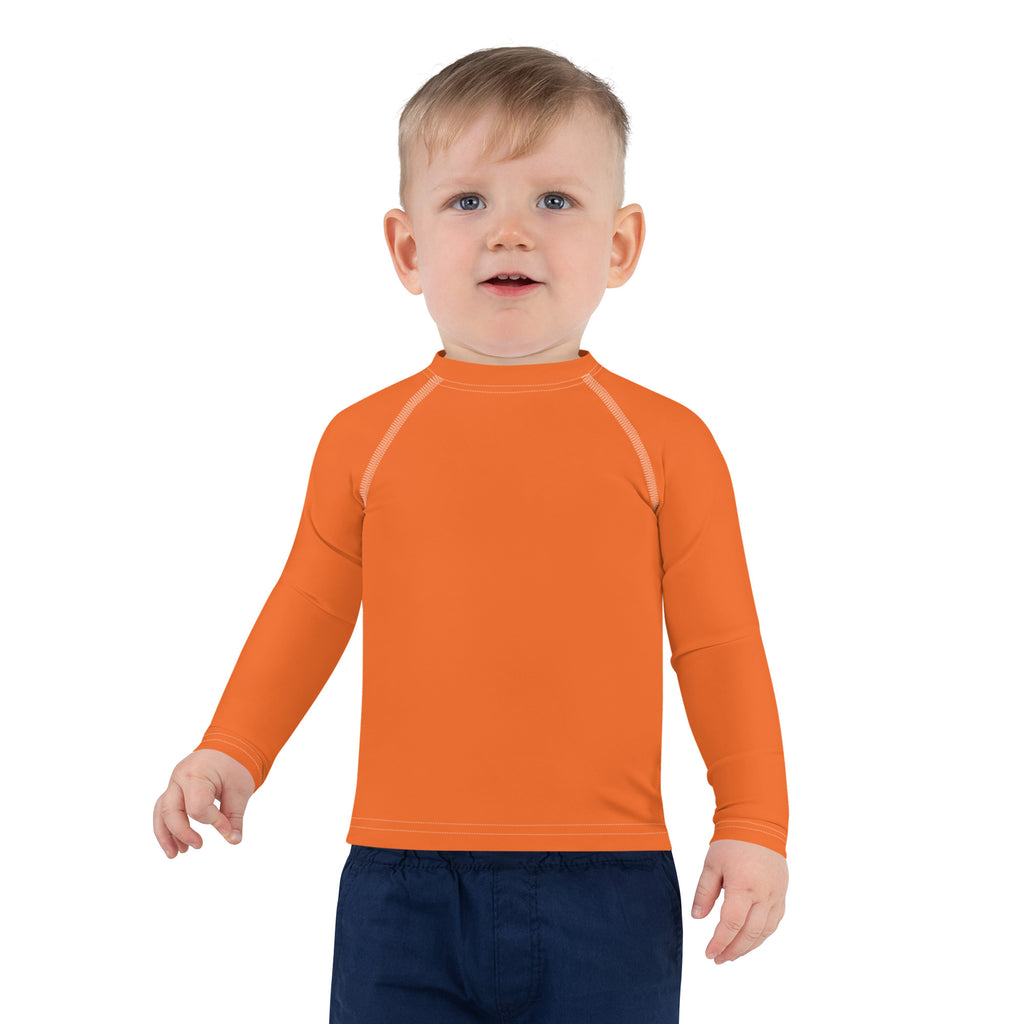 Kids orange long sleeve rash guard swim shirt with subtle white stitching and UPF 50 plus sun protection