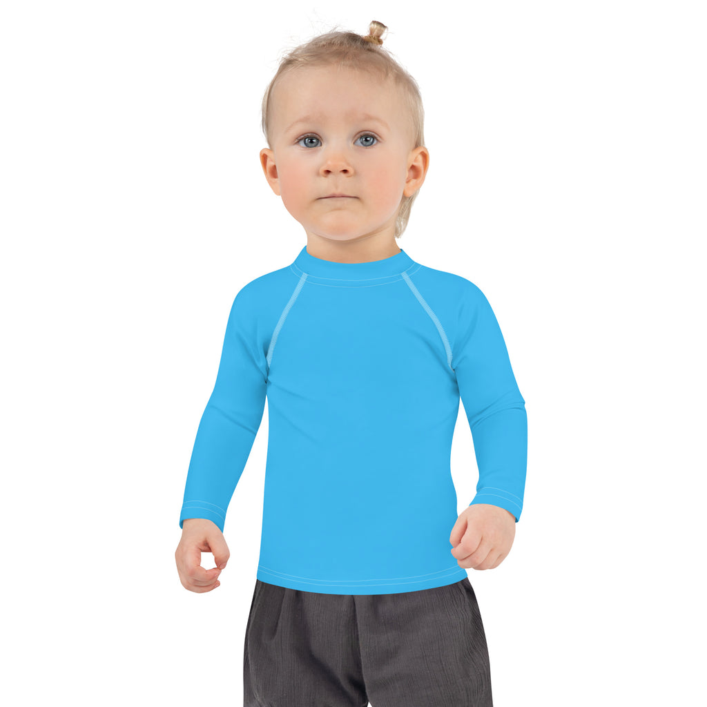Bright blue kids long sleeve rash guard swim shirt with subtle white seams and UPF 50 plus sun protection