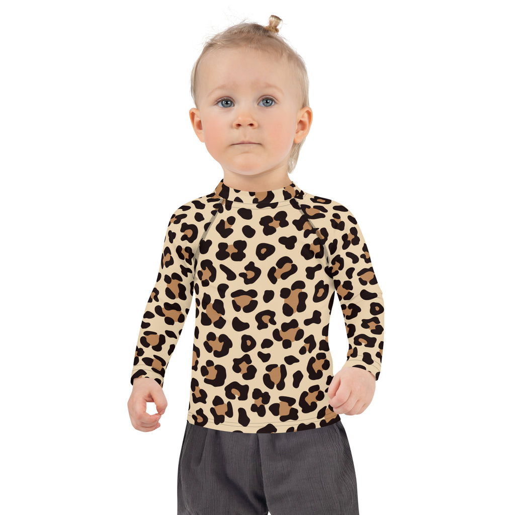 A child wearing a kids leopard print long sleeve rash guard swim shirt with upf 50 plus in beige and brown