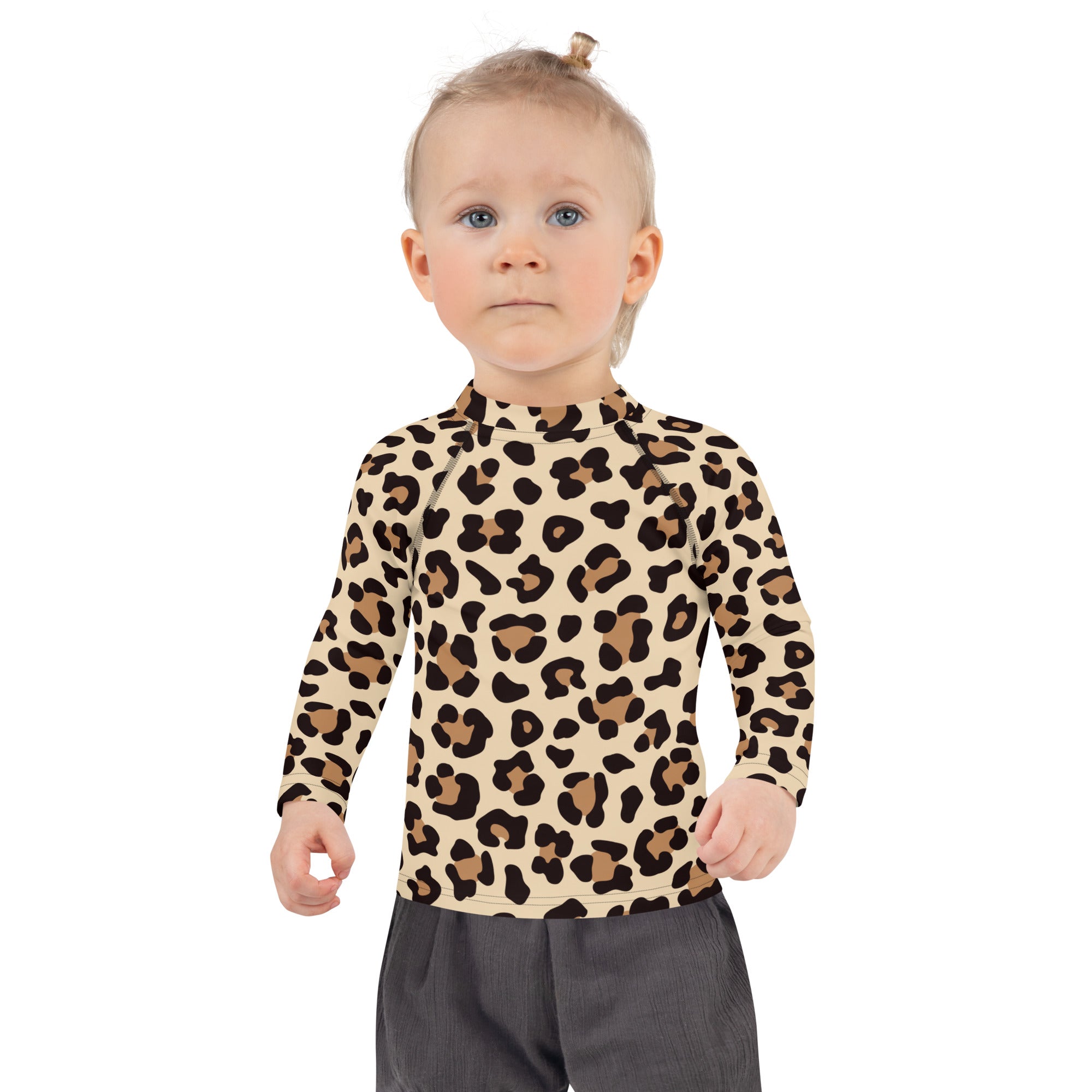 A child wearing a kids leopard print long sleeve rash guard swim shirt with upf 50 plus in beige and brown
