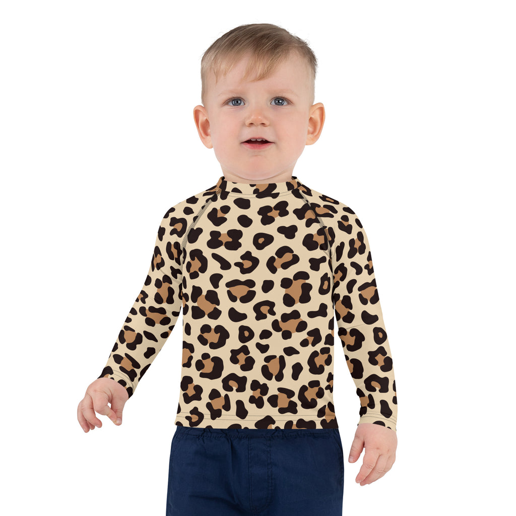 A child wearing a beige leopard print kids long sleeve rash guard swim shirt with UPF 50 plus protection