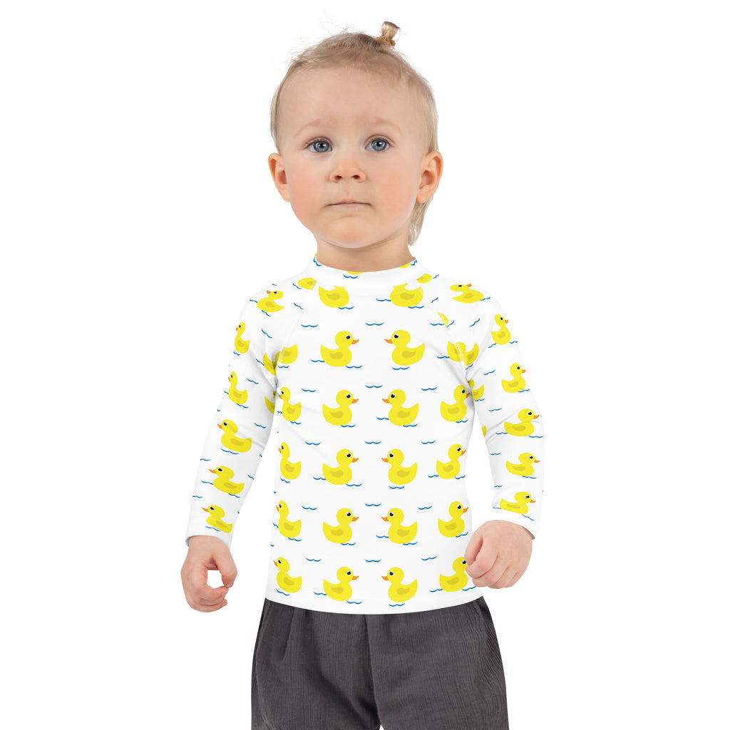 White long sleeve kids rash guard swim shirt with yellow rubber ducks blue waves pattern and upf 50 plus protection