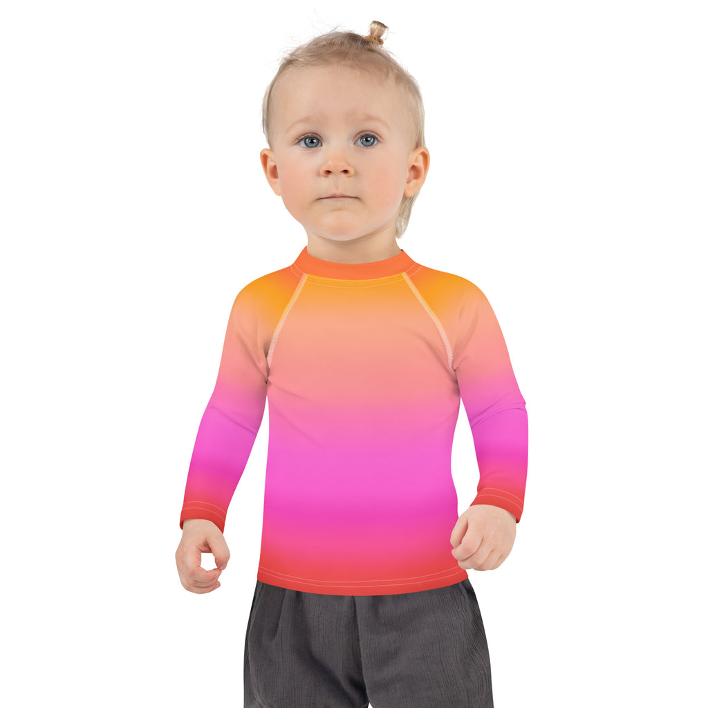 Girls sunset ombre long sleeve rash guard with a vibrant orange to pink red gradient and UPF 50 plus sun protection