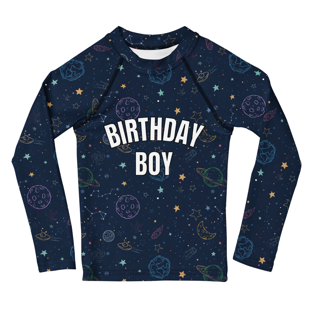 A navy blue long sleeve rash guard with a colorful galaxy space design and birthday boy text featuring upf 50+ protection