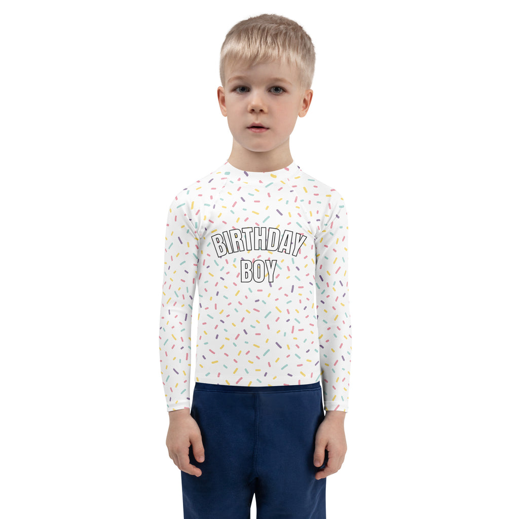 White long sleeve rash guard with birthday boy black lettering and colorful sprinkles pattern for sun protection UPF 50+
