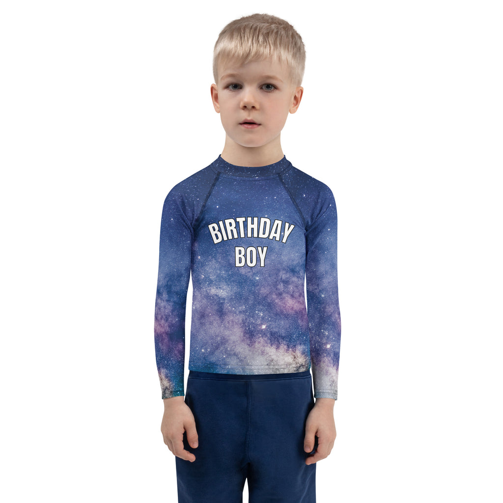 A child wearing a birthday boy galaxy long sleeve rash guard swim shirt with UPF 50 plus for sun protection