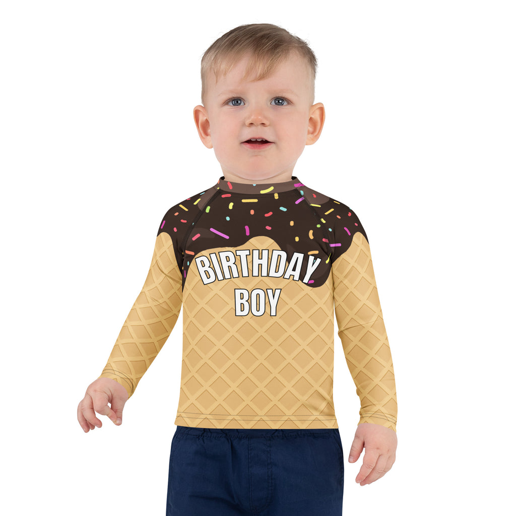 A child wearing a beige long sleeve birthday boy chocolate ice cream cone rash guard with UPF 50 plus protection