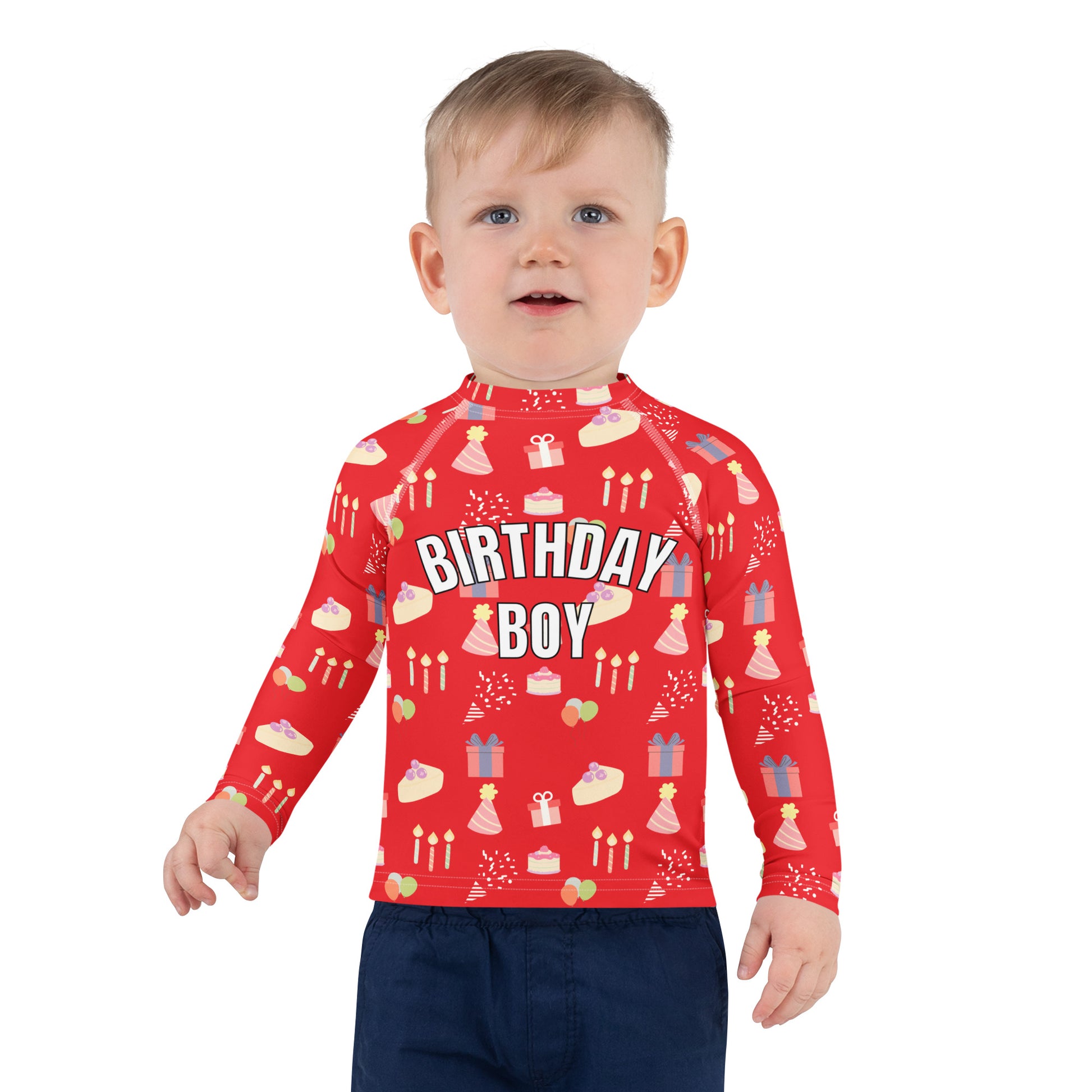 Toddler wearing a red 'Birthday Boy' shirt with birthday patterns on a white background