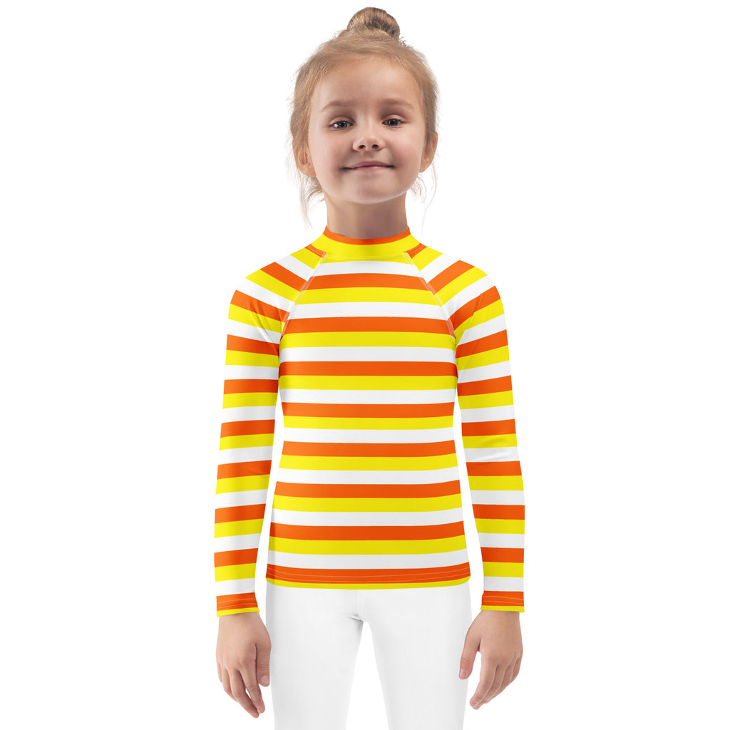 A kids long-sleeved rash guard with bold yellow orange and white candy corn stripes and UPF 50 plus swim shirt